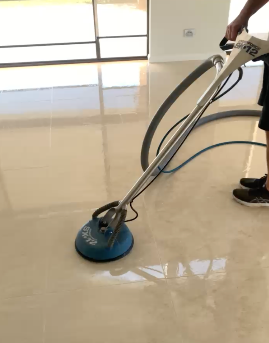 A Person is Using a Steam Cleaner to Clean a Tile Floor — Rugrats Carpet Cleaning Service In Old Bar, NSW