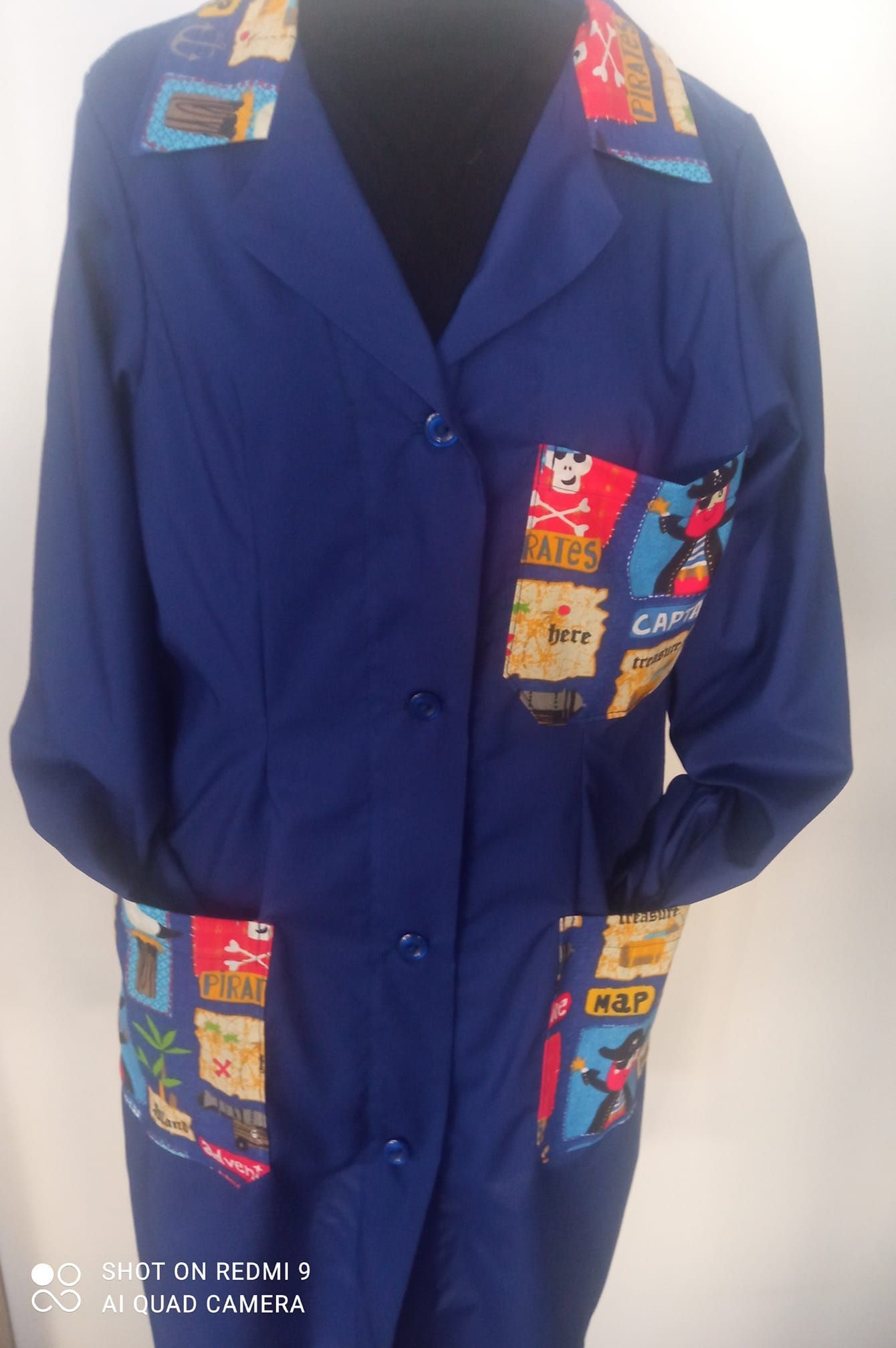 Un cappotto blu con un motivo sulle tasche è su un manichino
