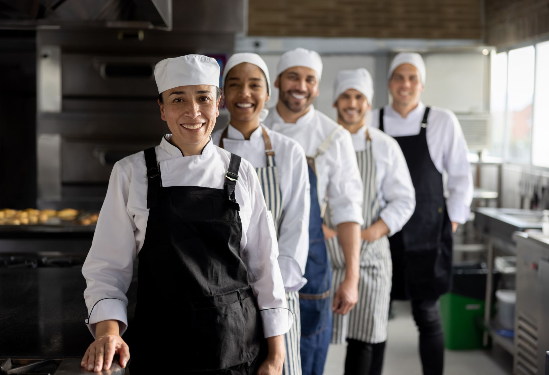 Un gruppo di chef posa per una foto in cucina.