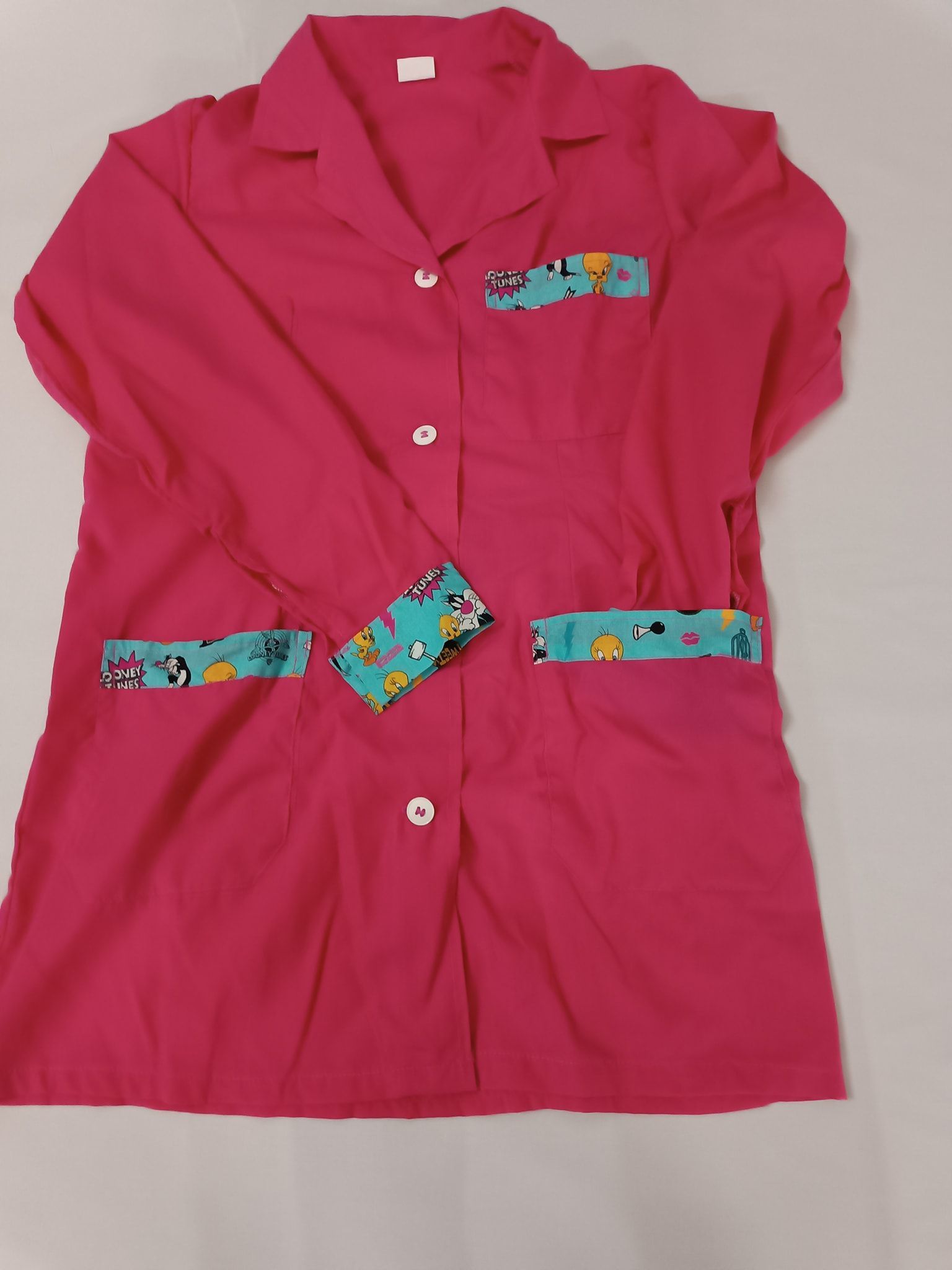 Una camicia rosa con tasche e bottoni blu