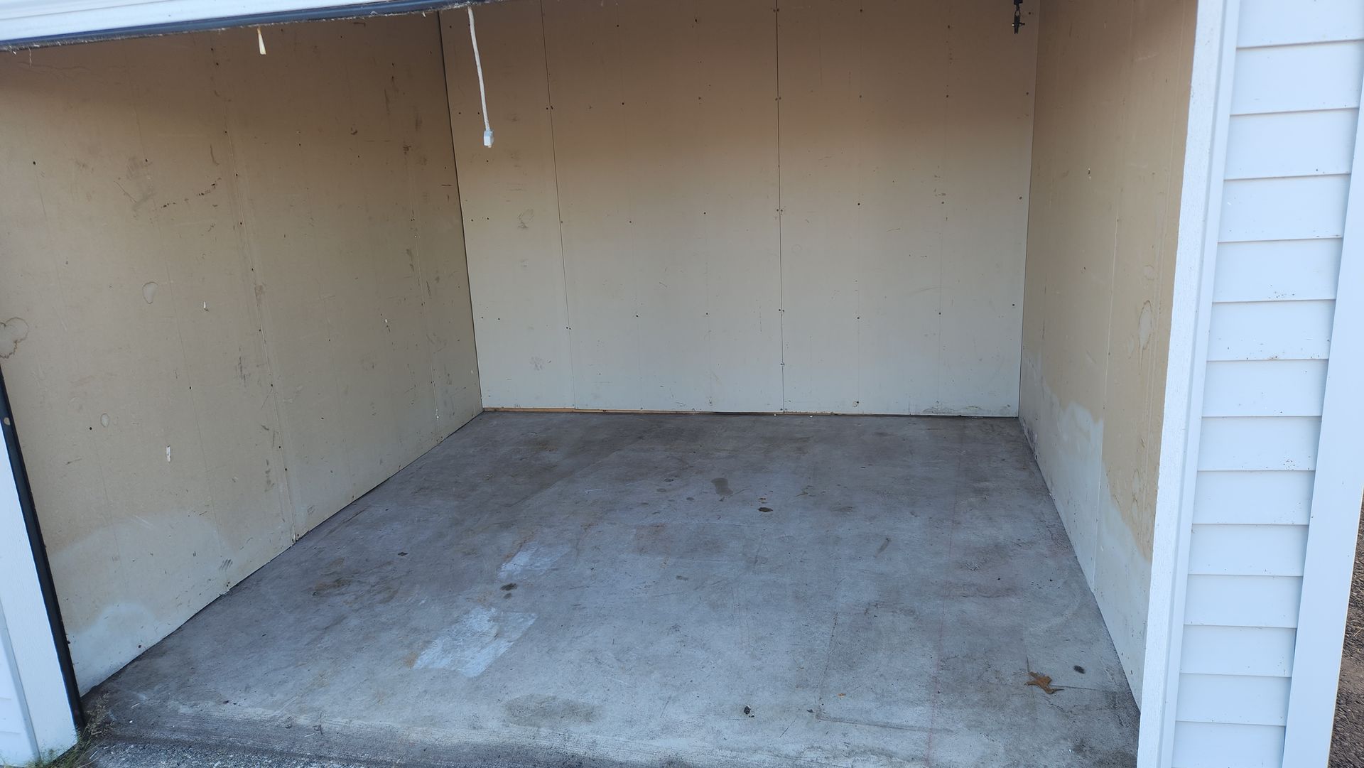 Empty outdoor storage shed with concrete floor and beige walls. Empty outdoor storage shed with concrete floor and beige walls.