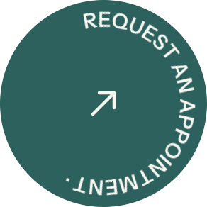 Green circular button with white curved text “REQUEST AN APPOINTMENT” and an arrow icon.