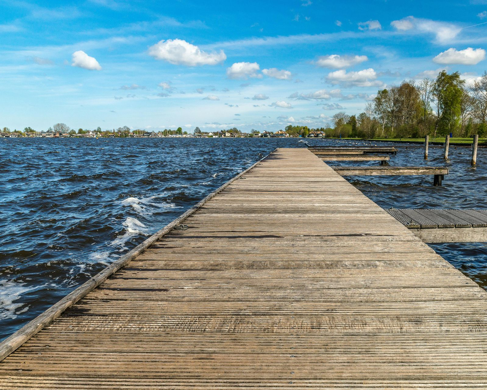 Vlonder die het meer in loopt, symbool voor reflectie, ruimte en leiderschapskeuzes