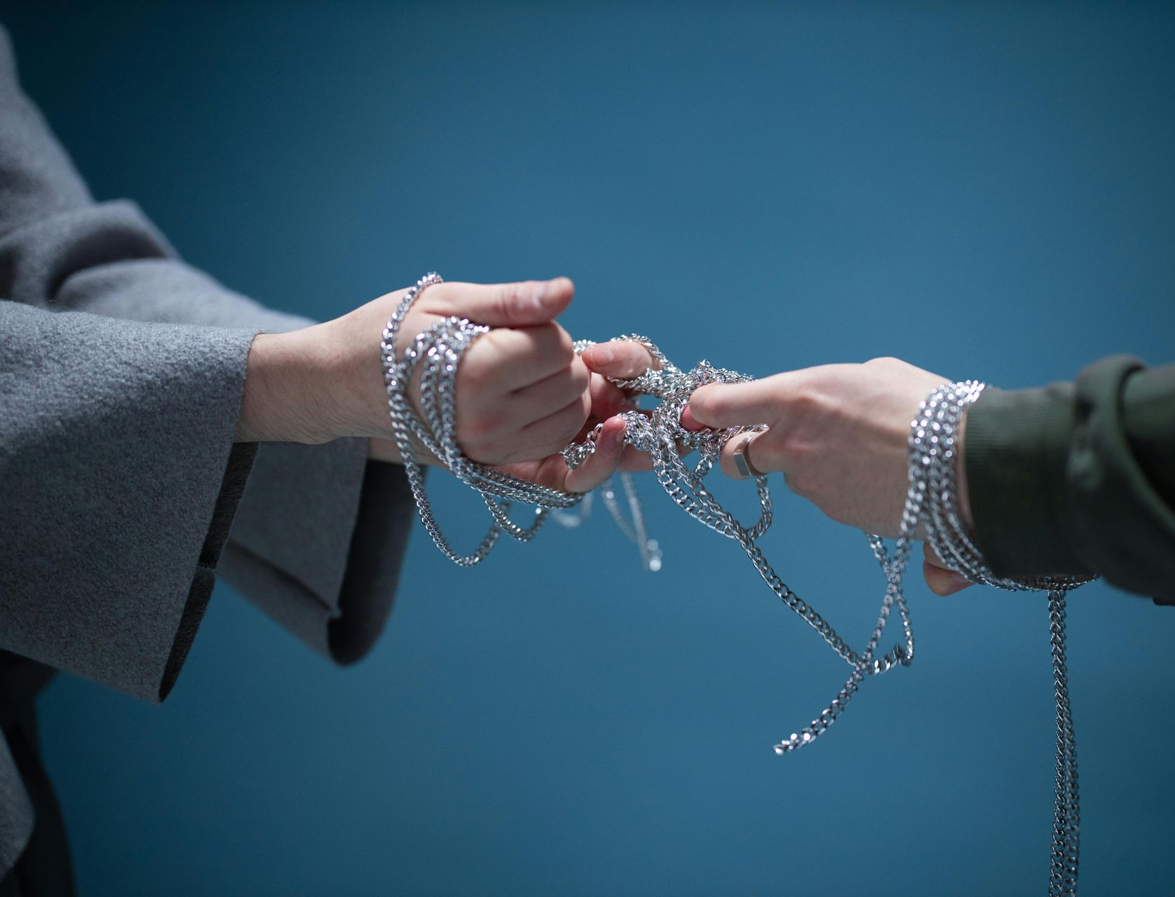 Twee handen trekken aan een ketting, beeld van spanning en gedeelde verantwoordelijkheid