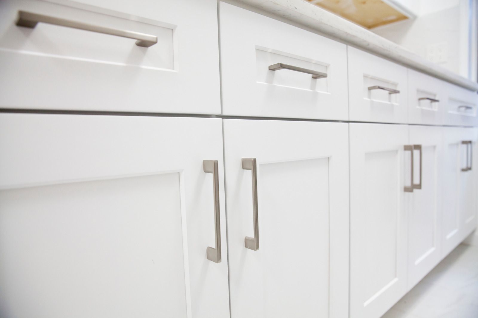 White kitchen cabinets with silver handles.