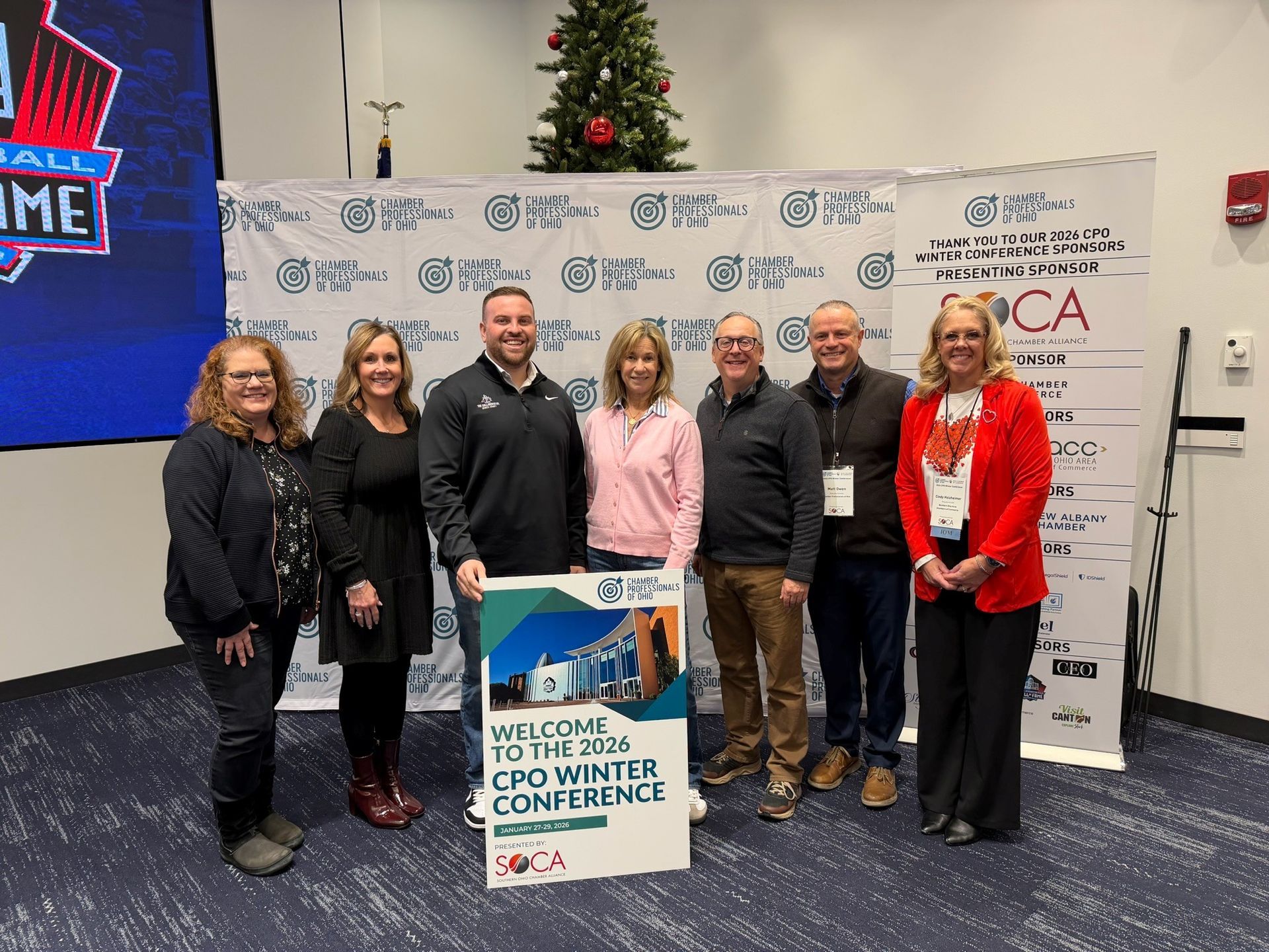 A group of women standing in front of a sign that says welcome to the 2015 cpo winter conference