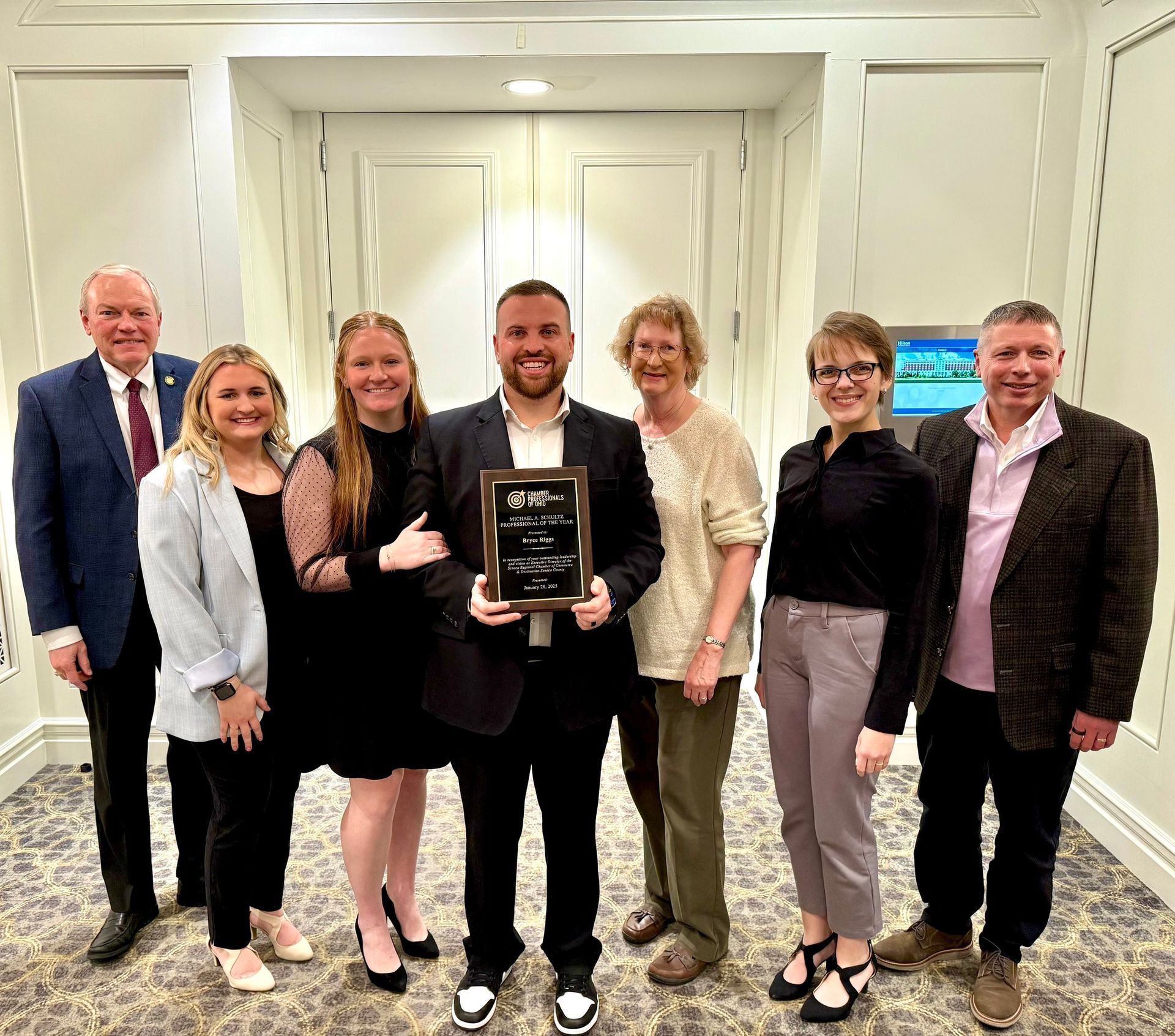 A group of people are posing for a picture with a man holding a plaque.