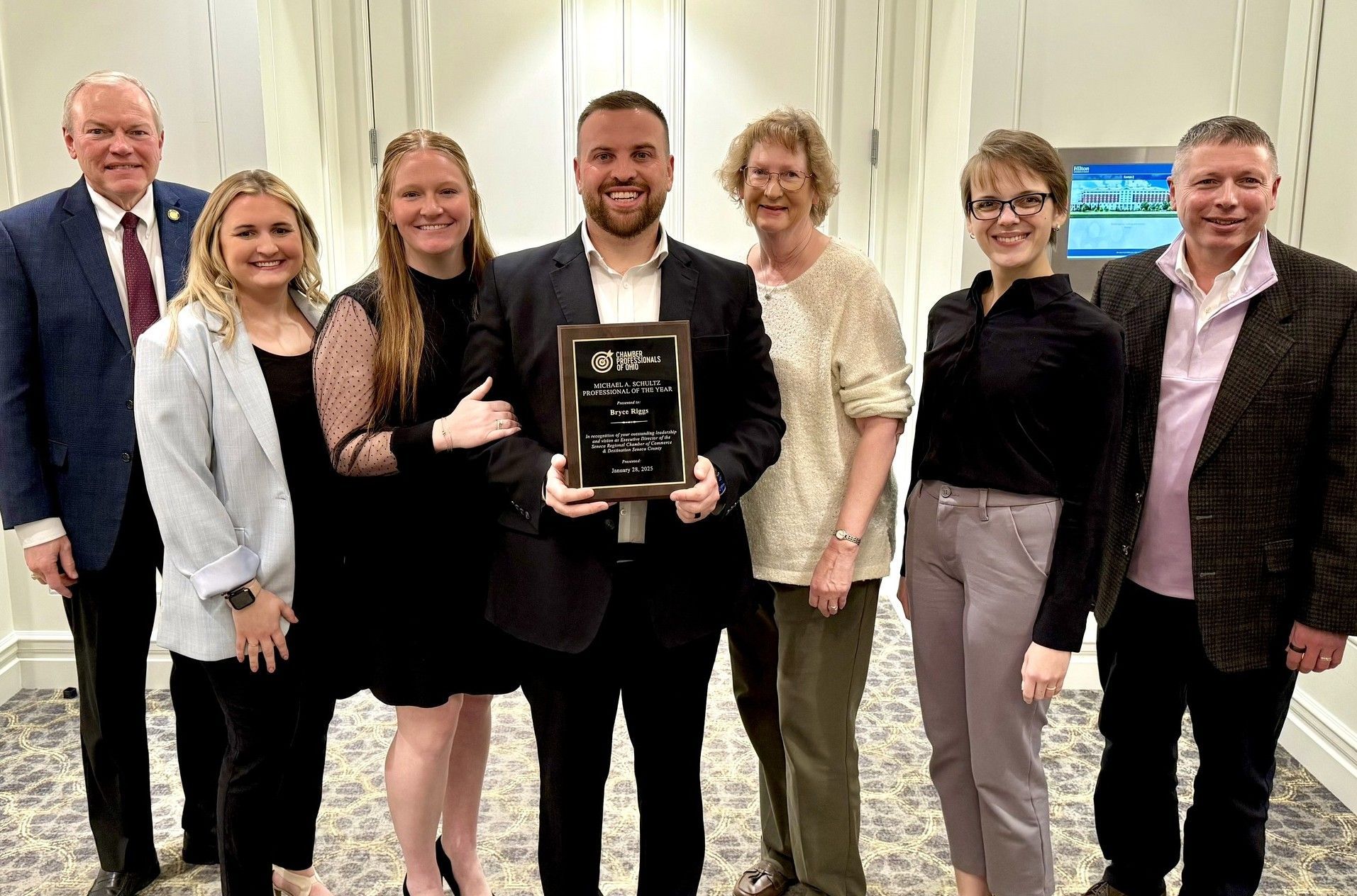 A group of people standing next to each other holding a plaque.