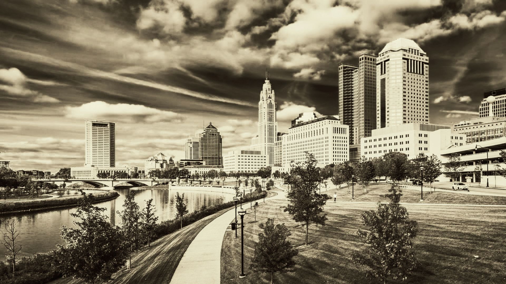 A black and white photo of a city skyline with a river in the foreground