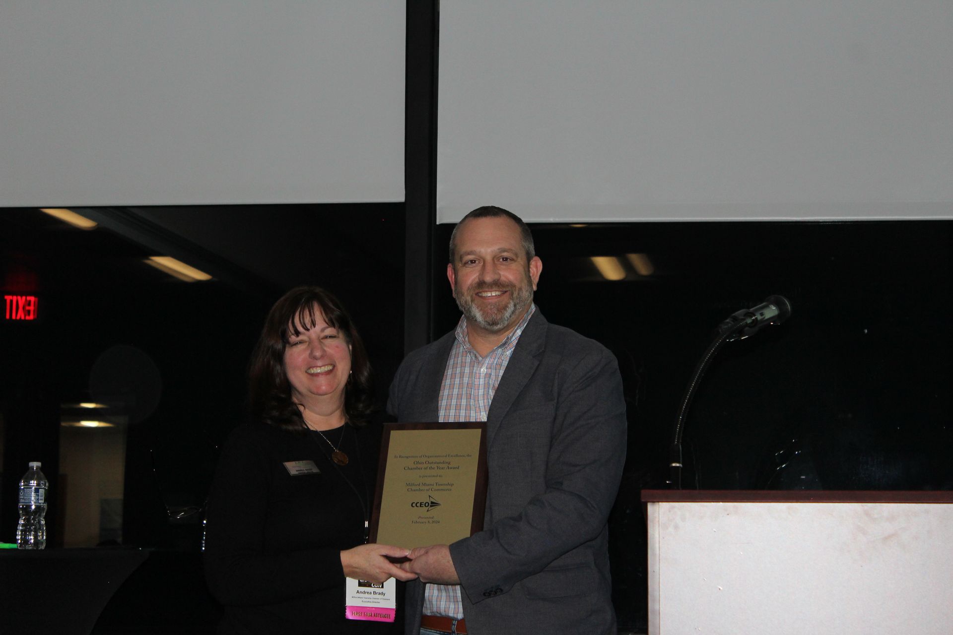 A man and a woman are standing next to each other holding a certificate.
