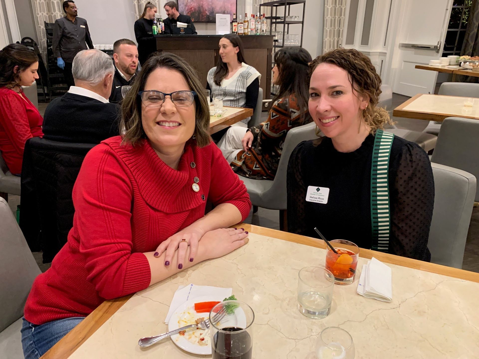 Two women are sitting at a table in a restaurant.