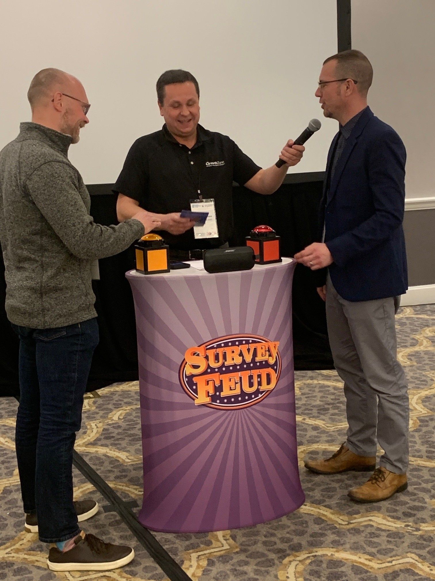 Three men are standing around a table that says survey mud