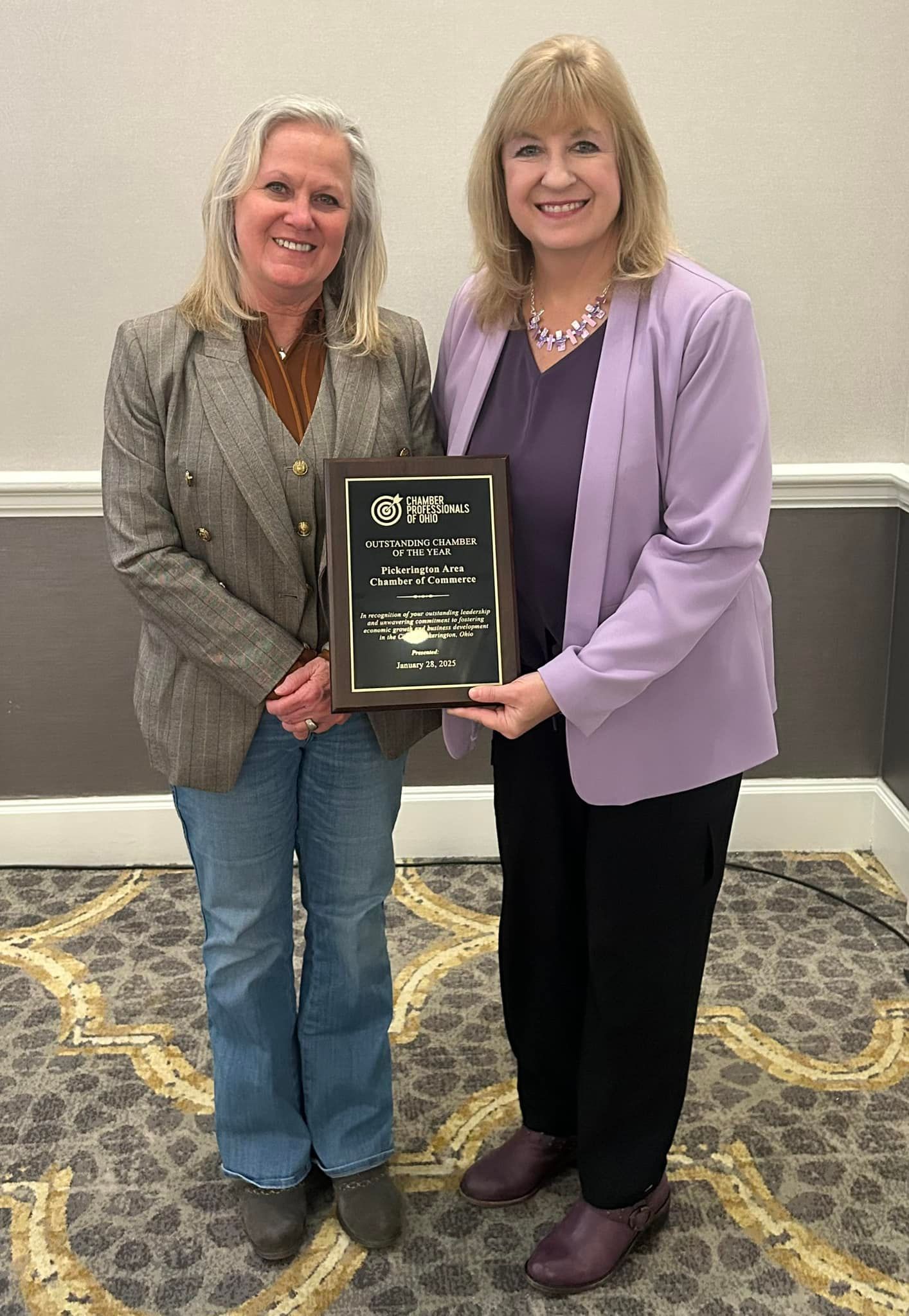 Two women are standing next to each other holding a plaque.