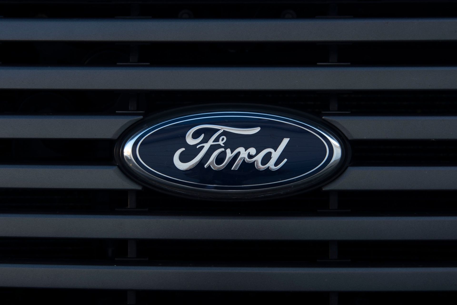 Logotipo de Chevrolet en una parrilla cromada de un automóvil con fondo azul.