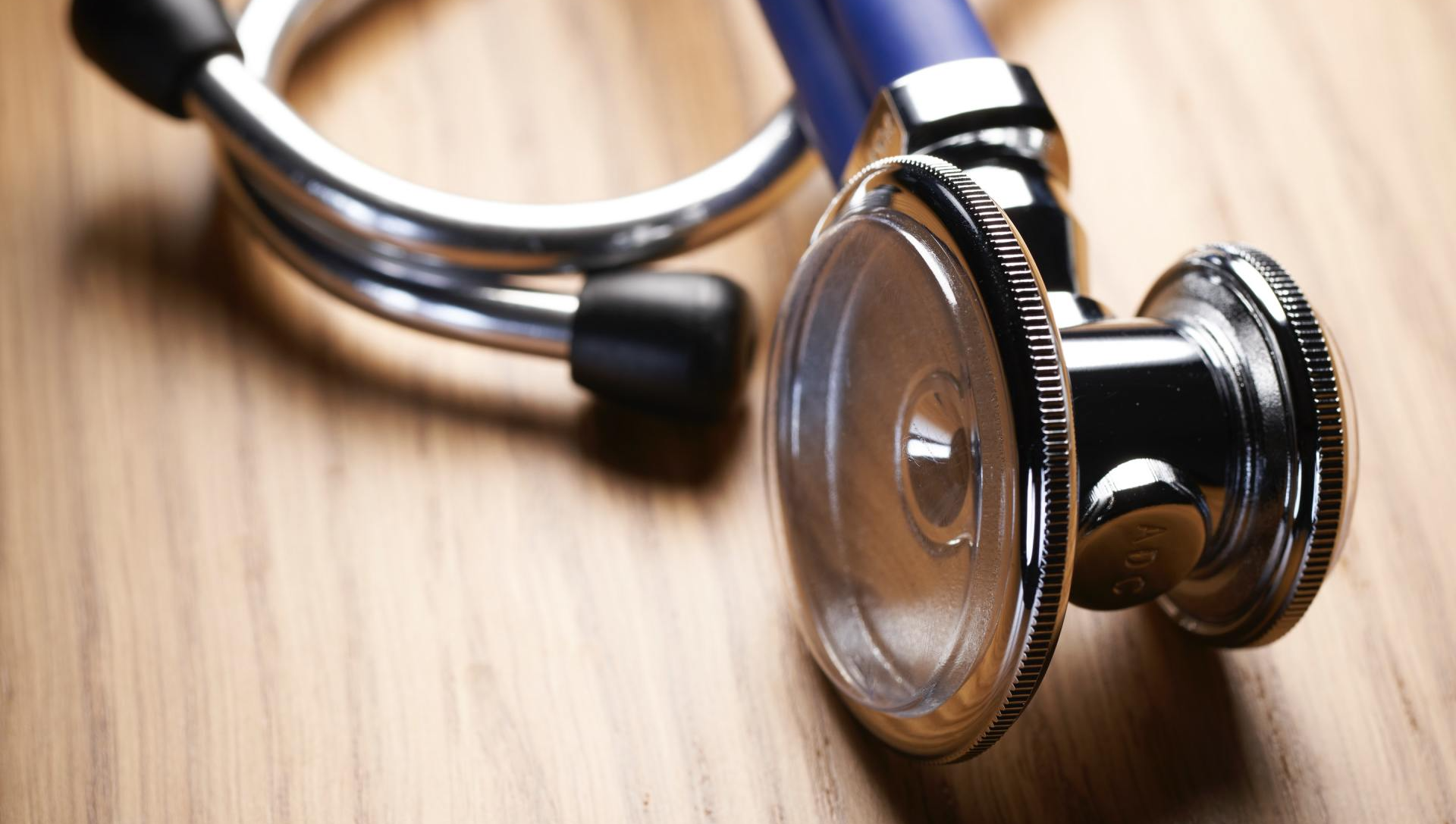 A close up of a stethoscope on a wooden table