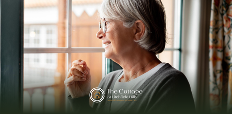 A senior staring through a window