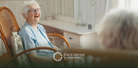 A senior sitting on a chair, laughing