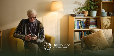 A senior sitting alone using his phone