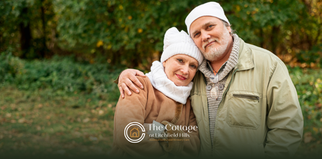 An elderly couple wearing jackets and beanies during cold weather