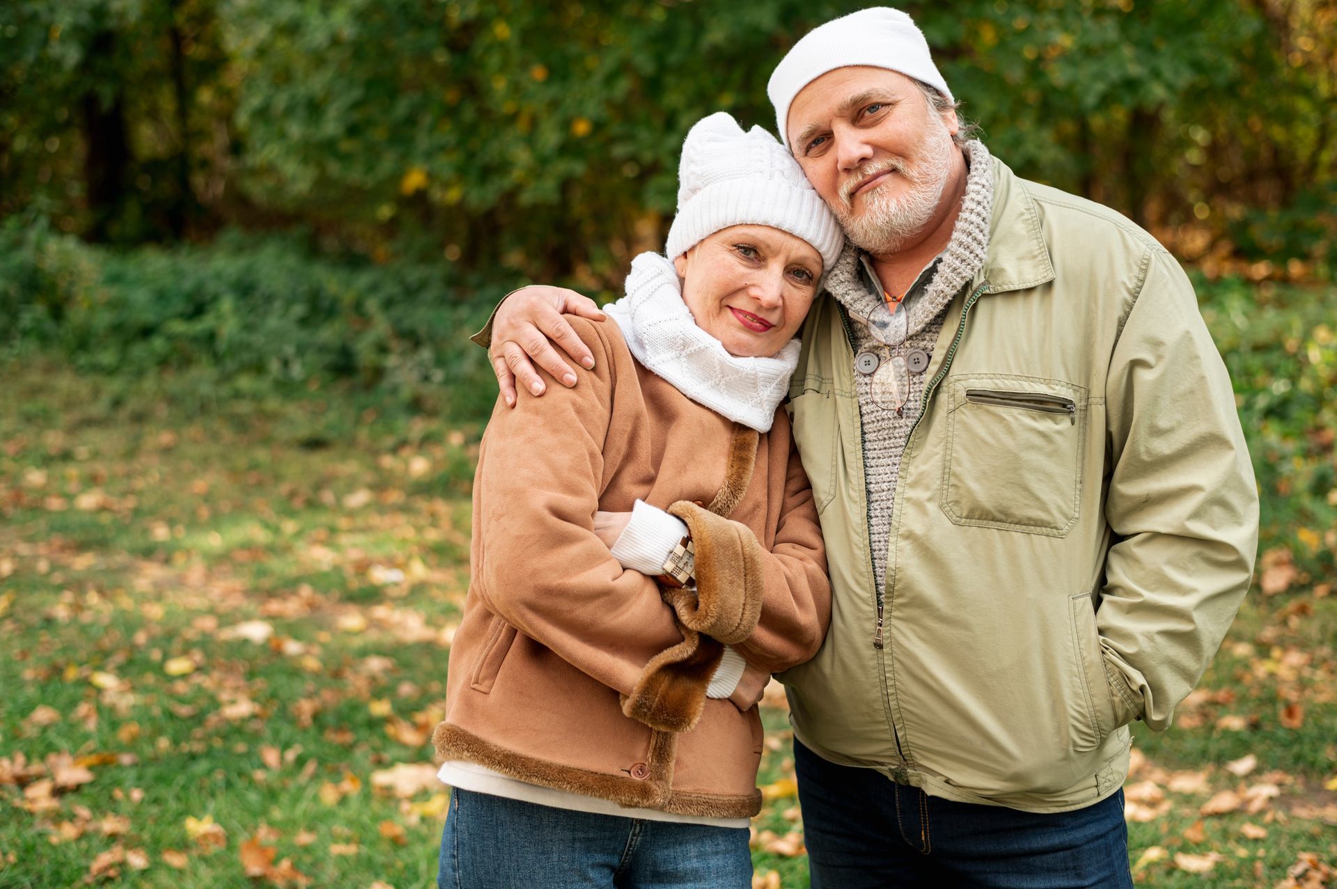 An elderly couple wearing jackets and beanies during cold weather