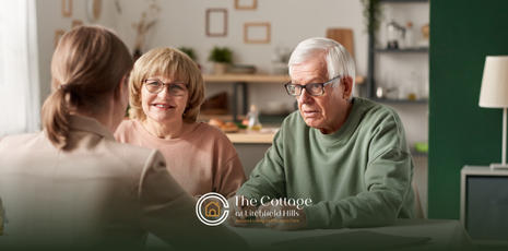 An elderly couple talking to a respite care staff member during consultation