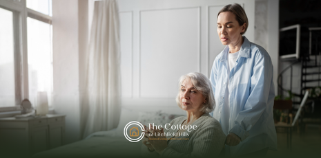 A woman standing behind a senior in a wheelchair