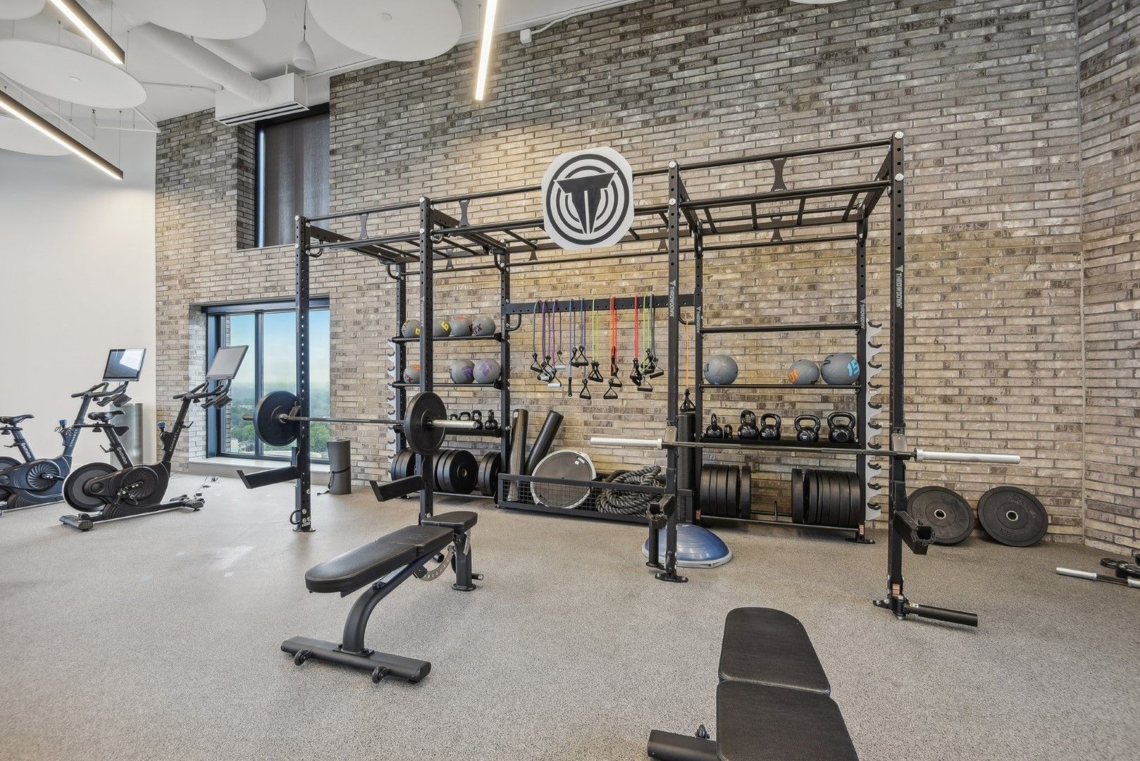 A gym with a brick wall and lots of exercise equipment.