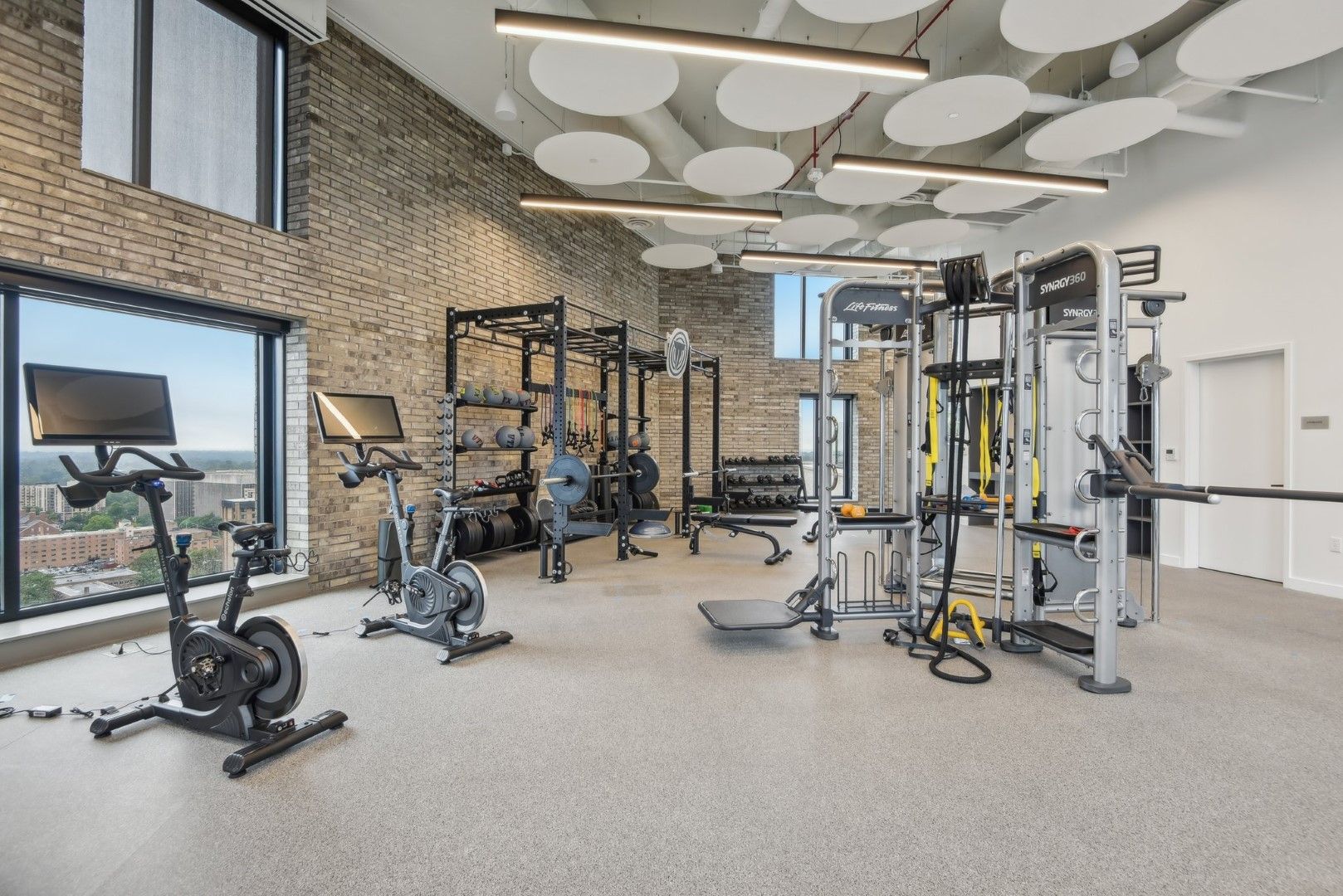 A large gym with a lot of equipment and a large window.