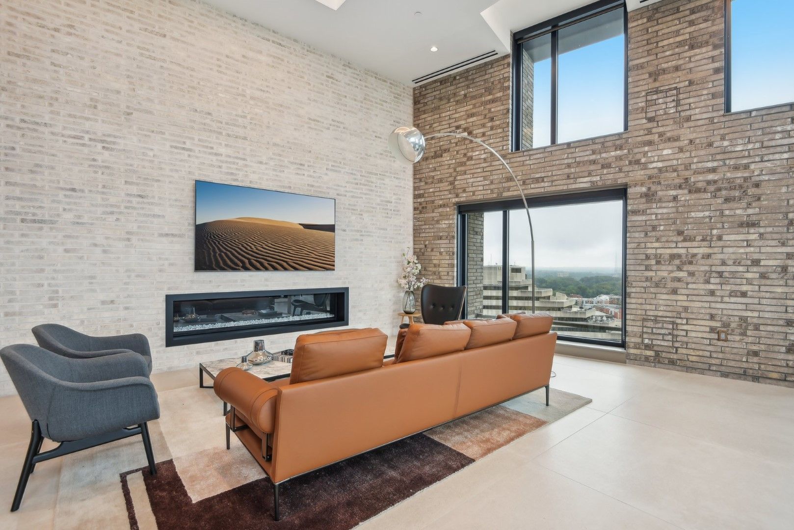 A living room with a couch , chairs , and a fireplace.