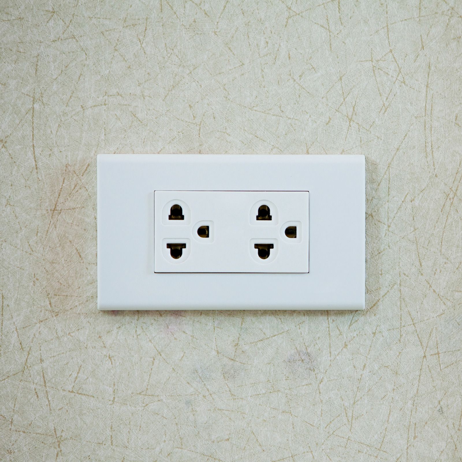 White electrical outlet plate on a beige textured wall.