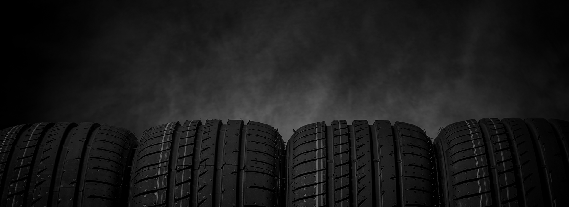 Row of tires in front of black abstract background | Marlin's Auto Service