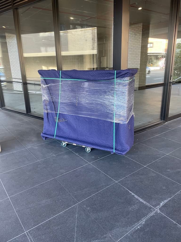 Blue mesh-covered cart in front of glass doors on a tiled walkway