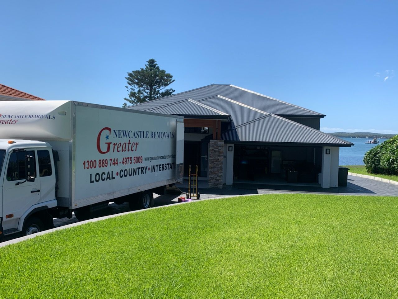 Food truck parked beside a waterfront building on a sunny day