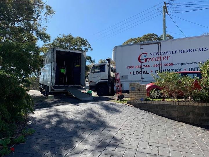 White truck unloading at a general removals business entrance on a sunny day