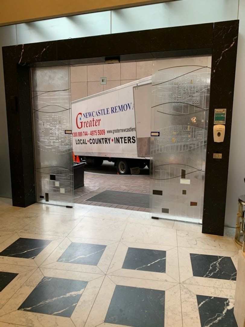 Glass entryway with a truck visible behind frosted doors in a building lobby