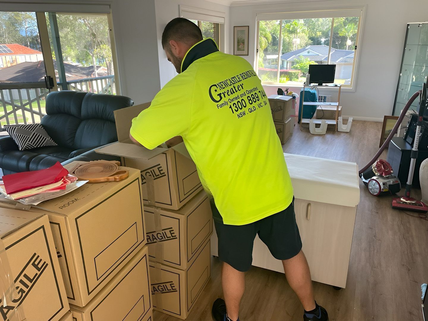 Worker in neon yellow shirt unloading boxes in a bright room