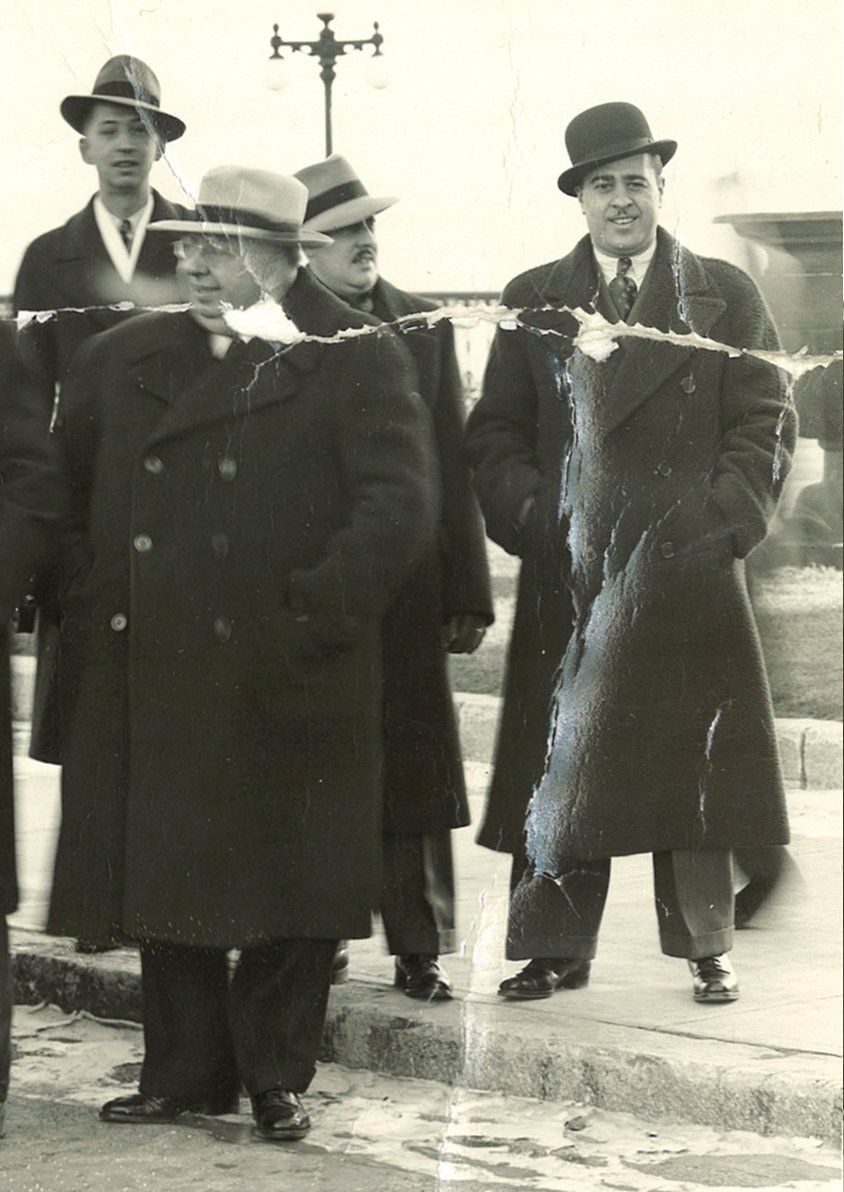 A group of men standing next to each other holding a large fish