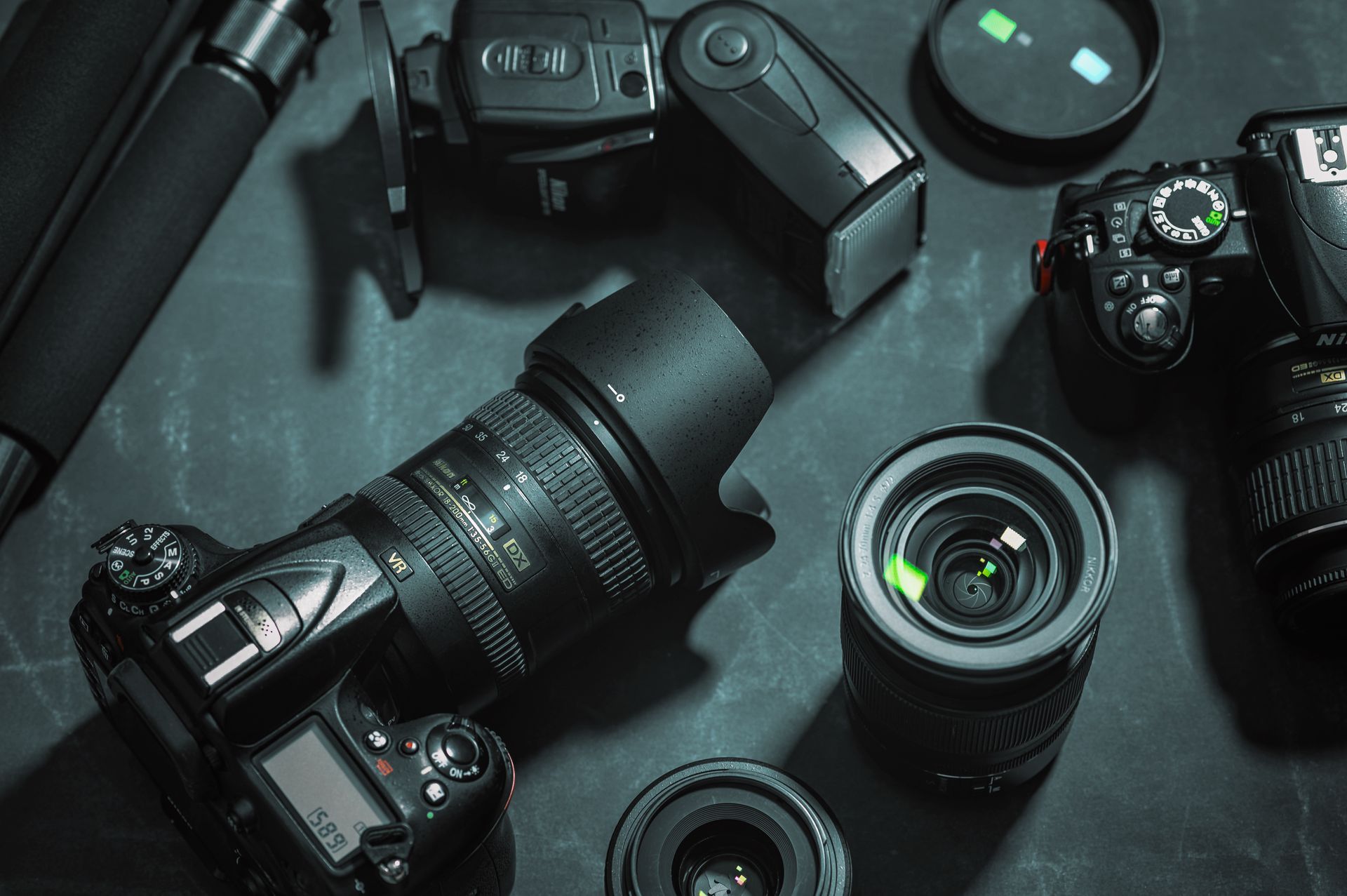 A group of cameras and lenses are sitting on a table.