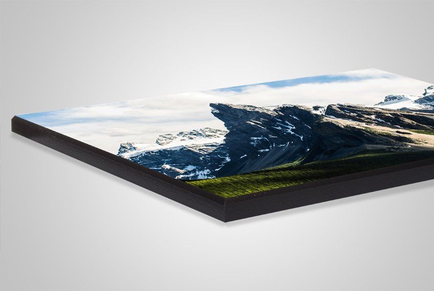 A picture of a mountain landscape on a wooden board.