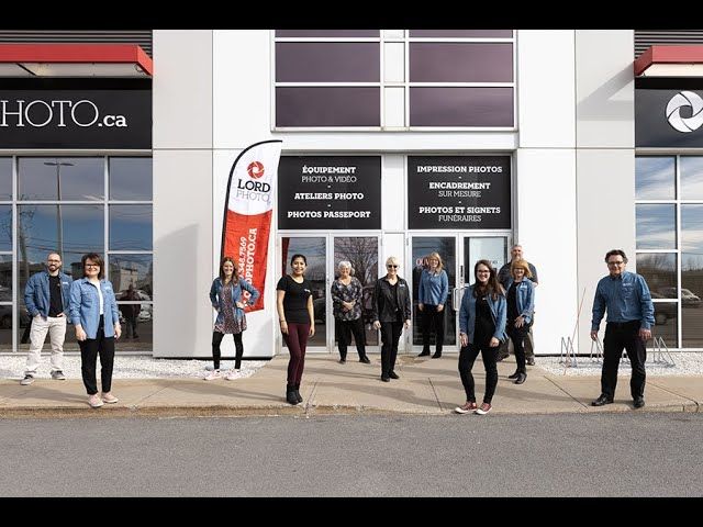Un groupe de personnes se tient devant un immeuble.