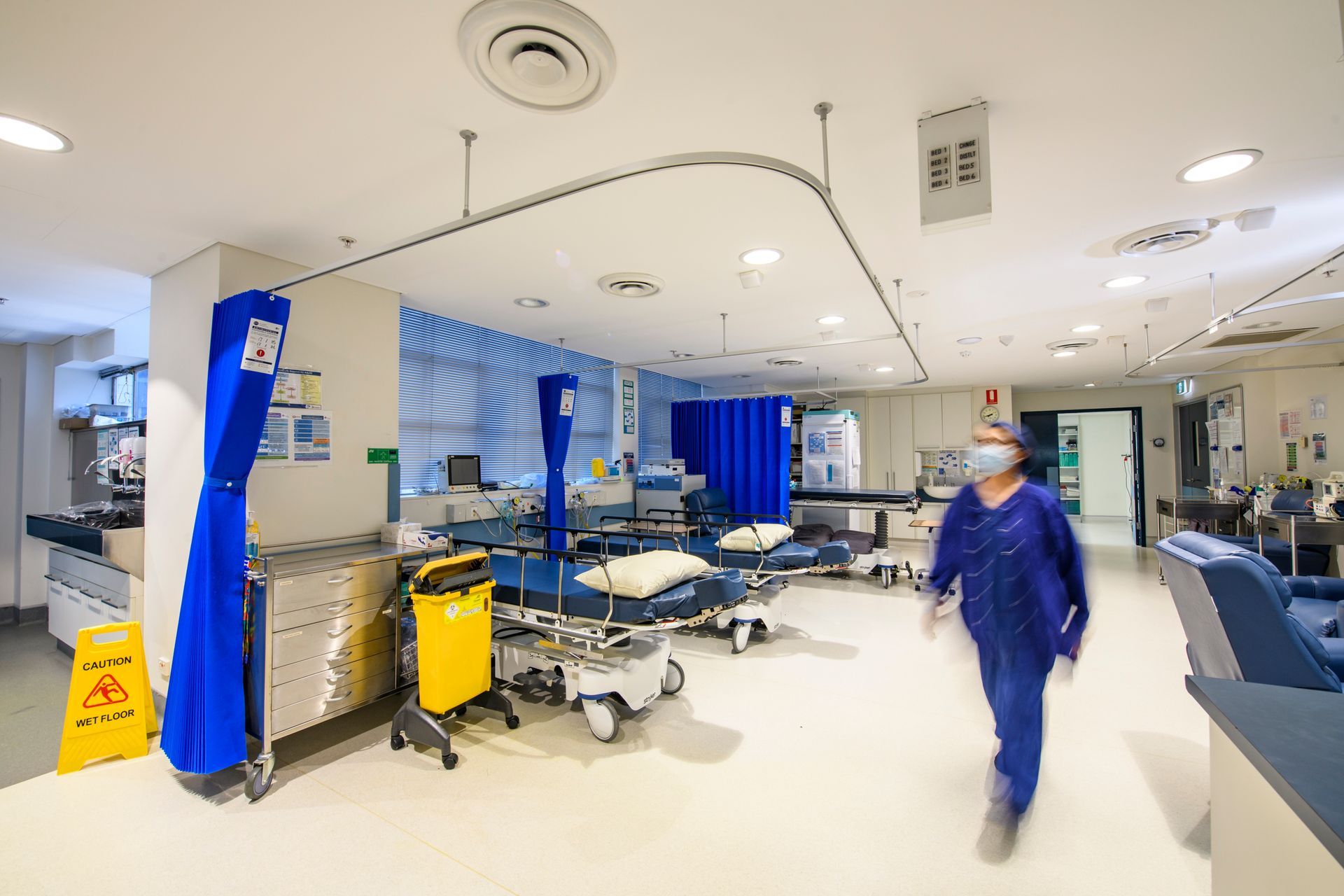 Surgeons operating using specialized equipment in a sterile operating room setting.