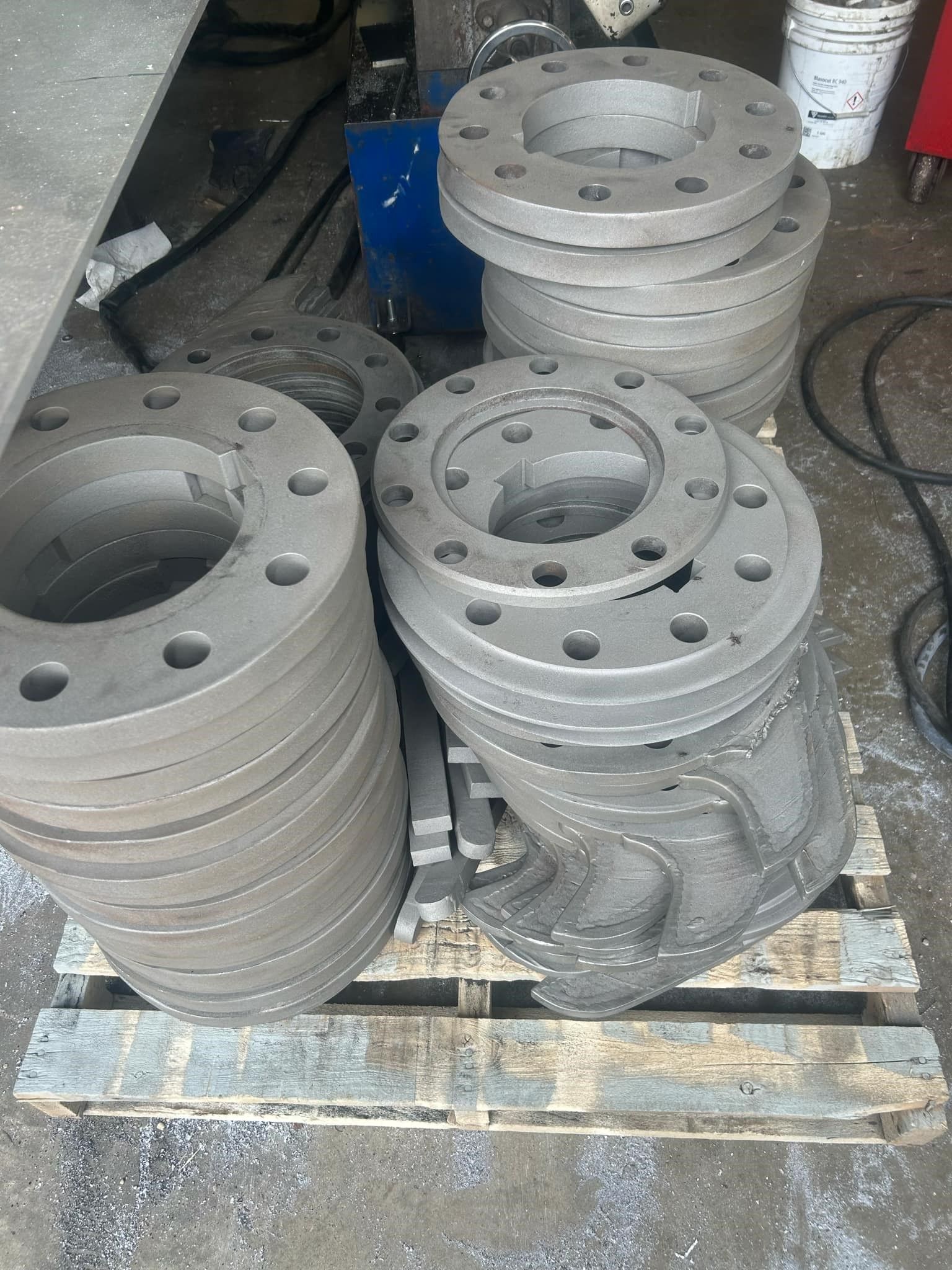A pile of metal pieces sitting on top of a wooden pallet.