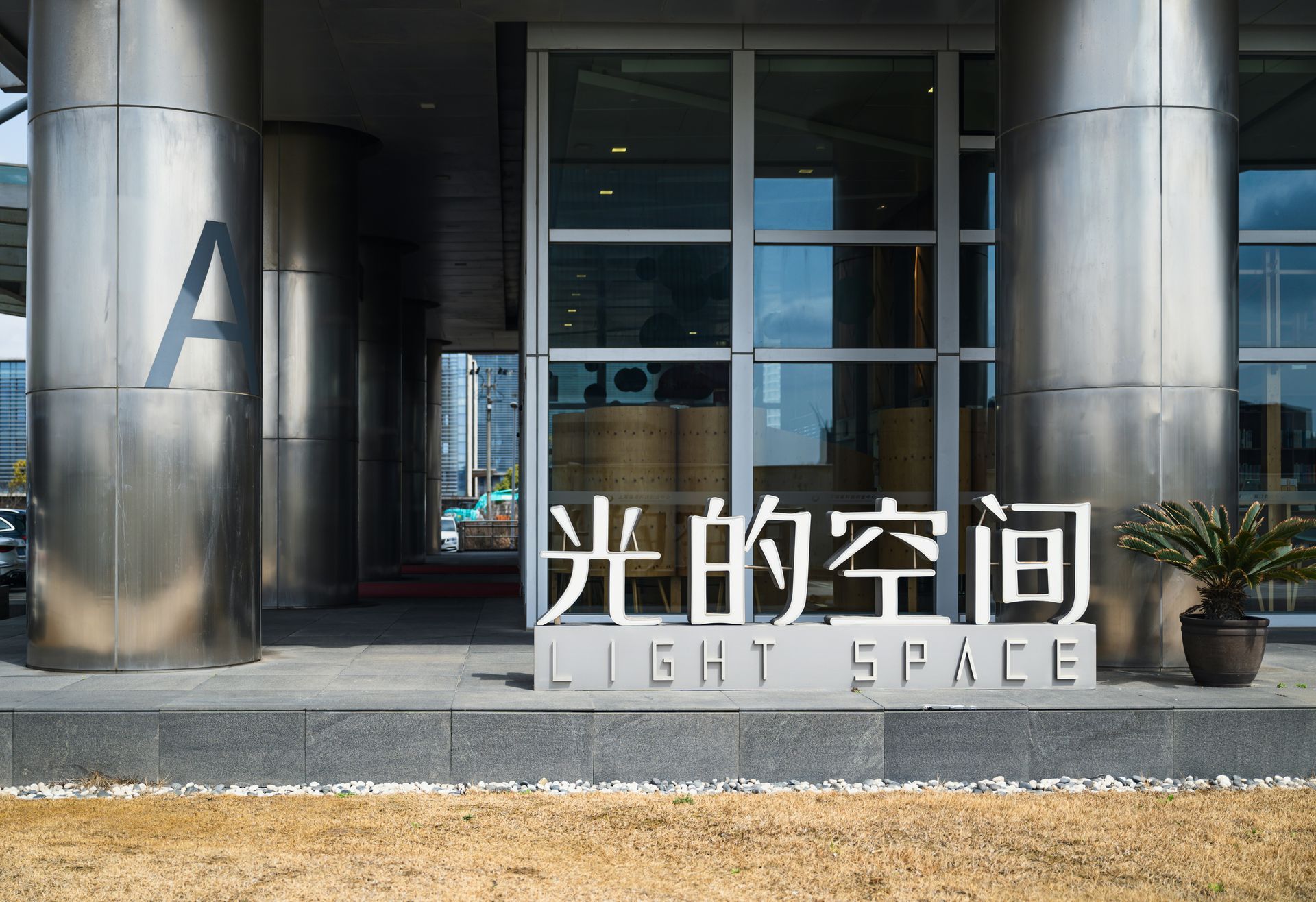 Entrance to a modern building with large metal signage reading “Light Space”.