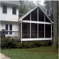 A screened in porch on the side of a house