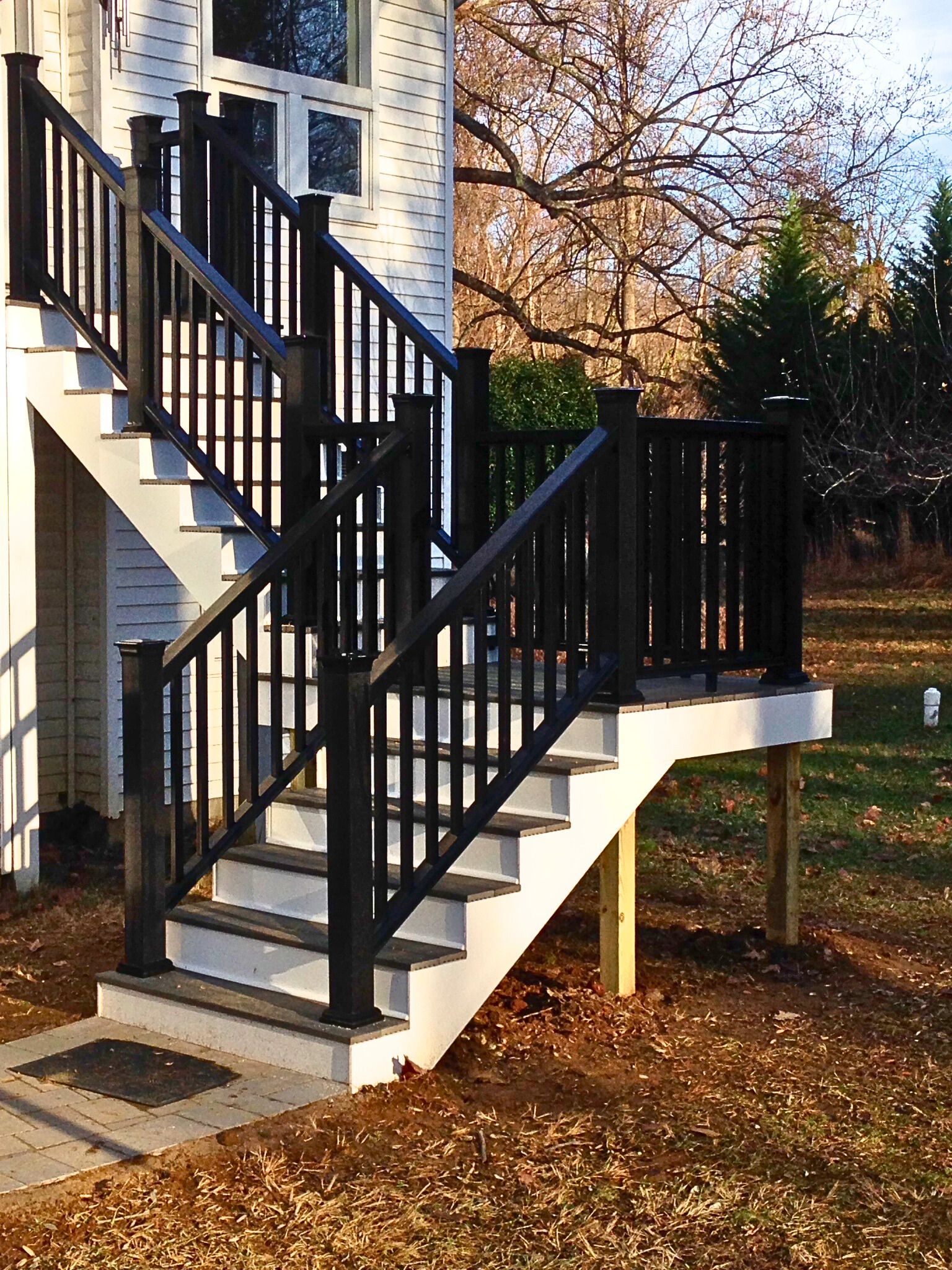 A set of stairs leading up to a house with a black railing