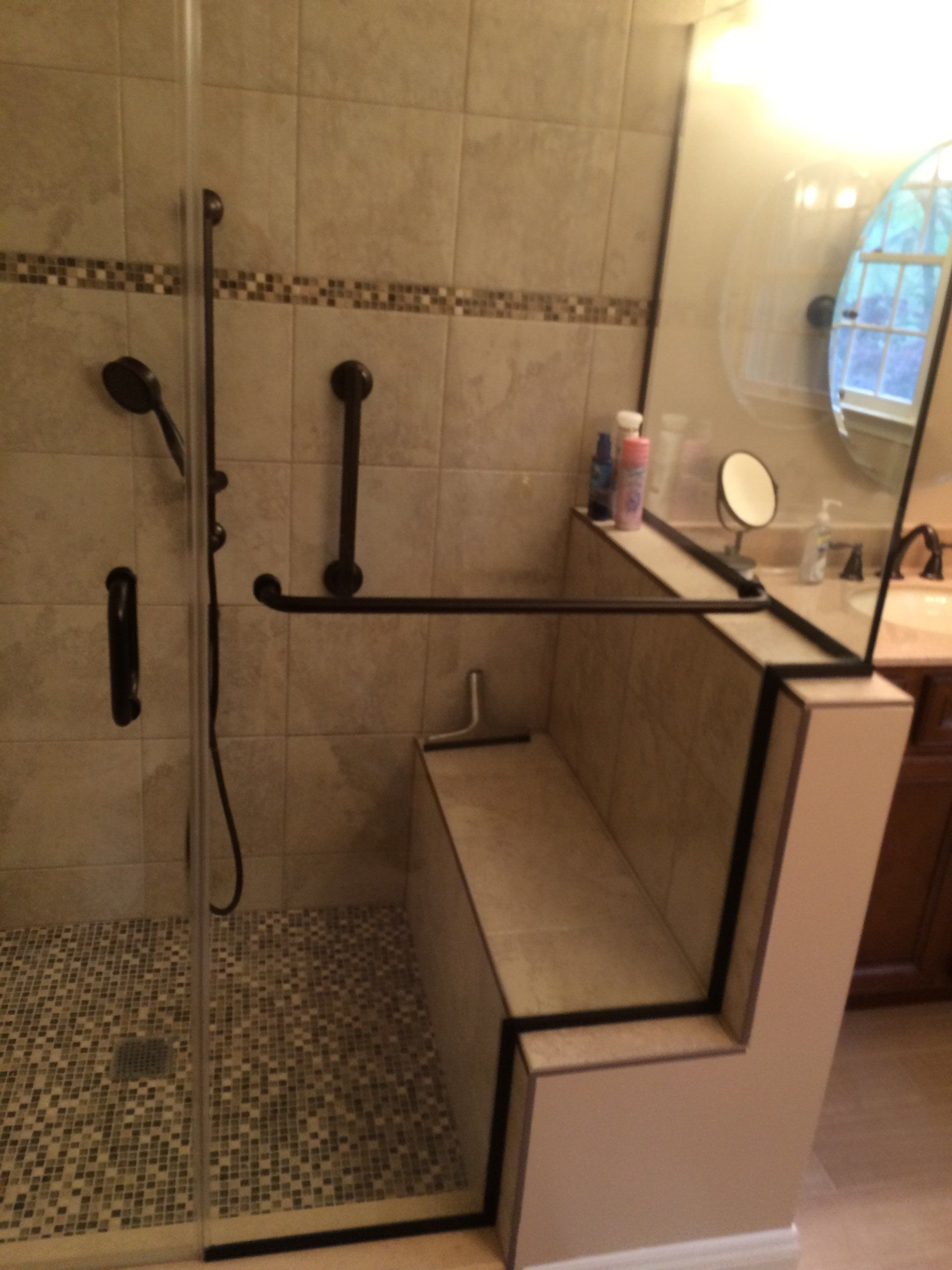 A bathroom with a walk in shower and a bench