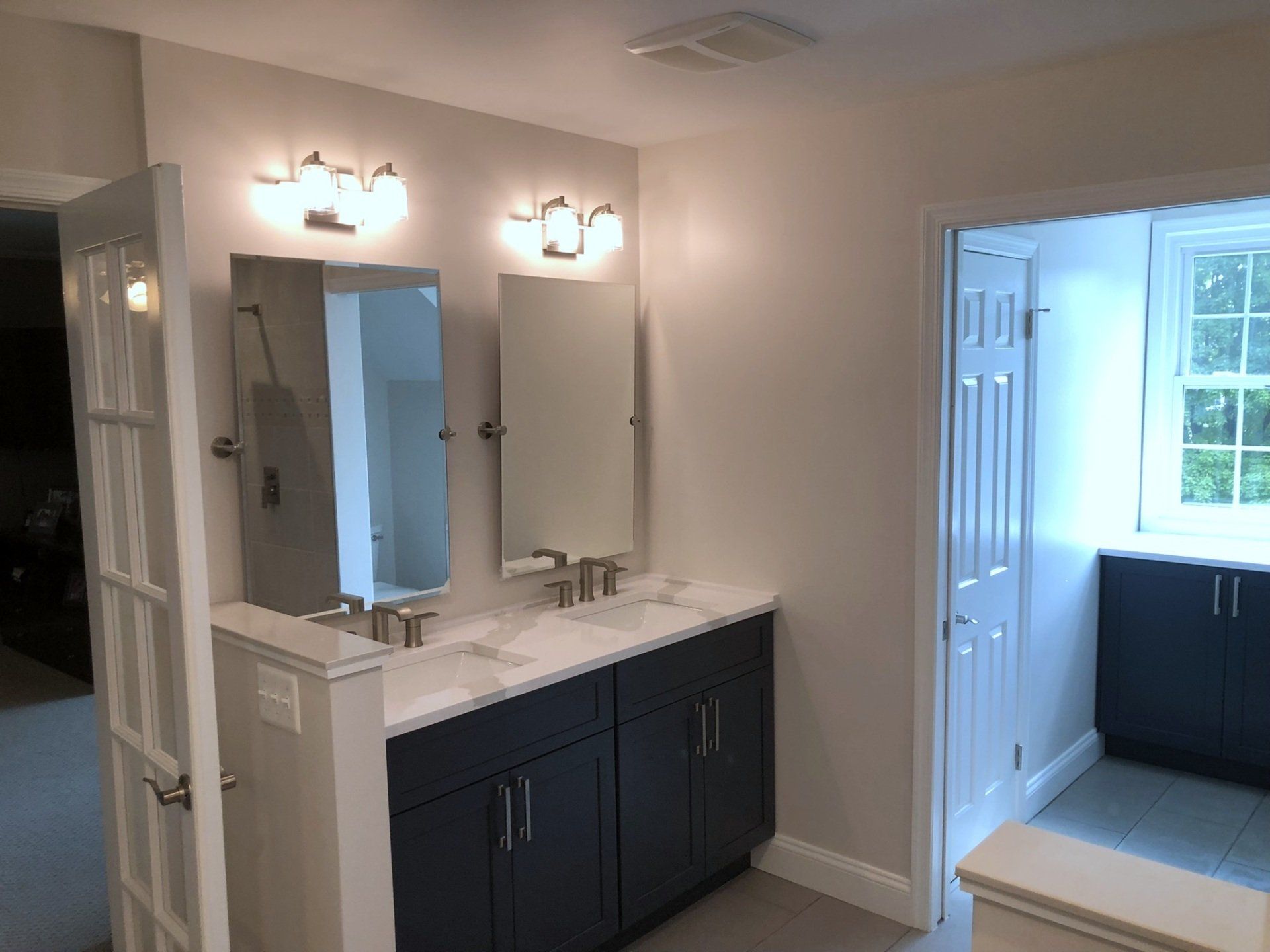 A bathroom with two sinks and two mirrors.