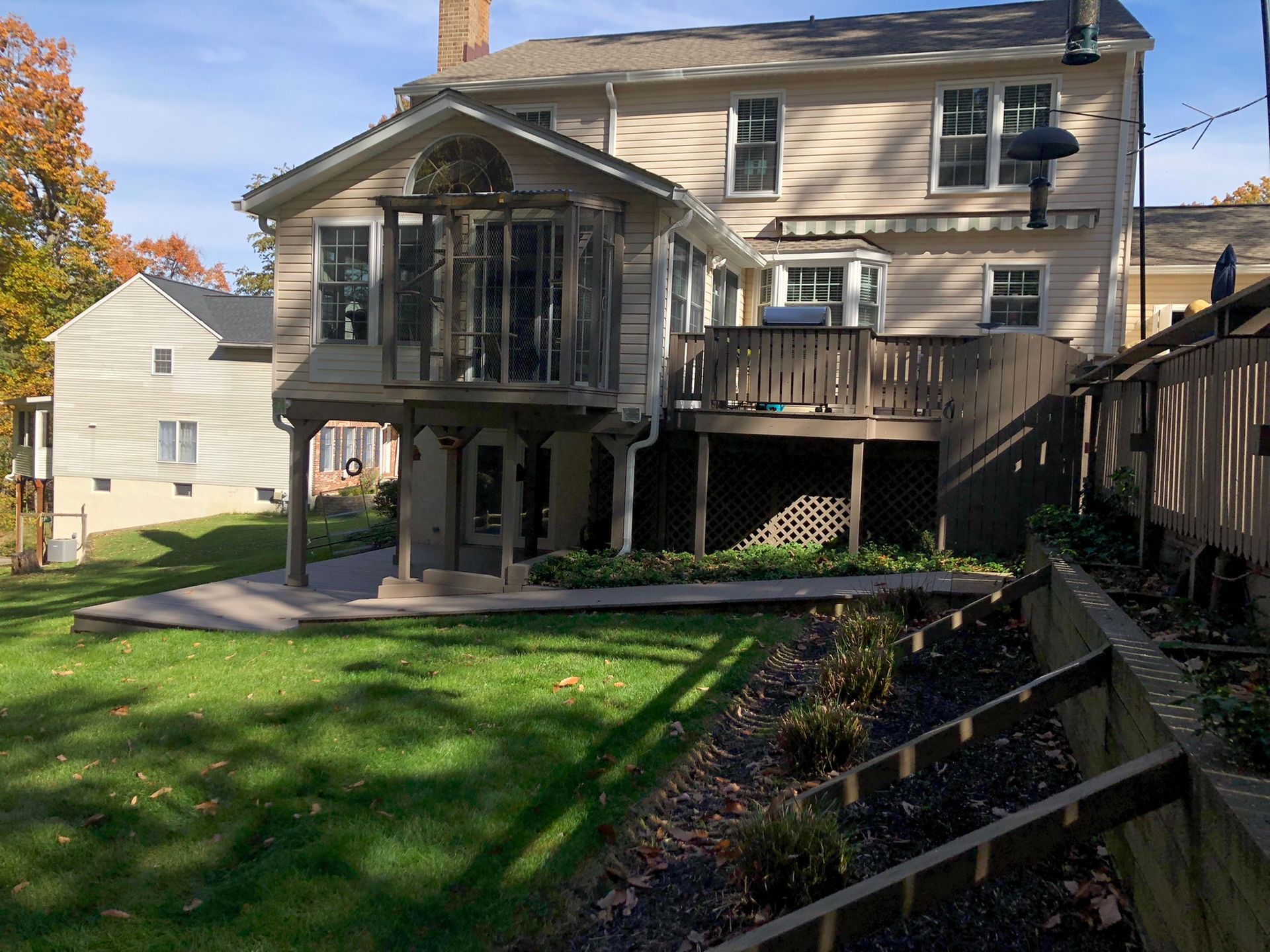 The back of a house with a large deck and a fence