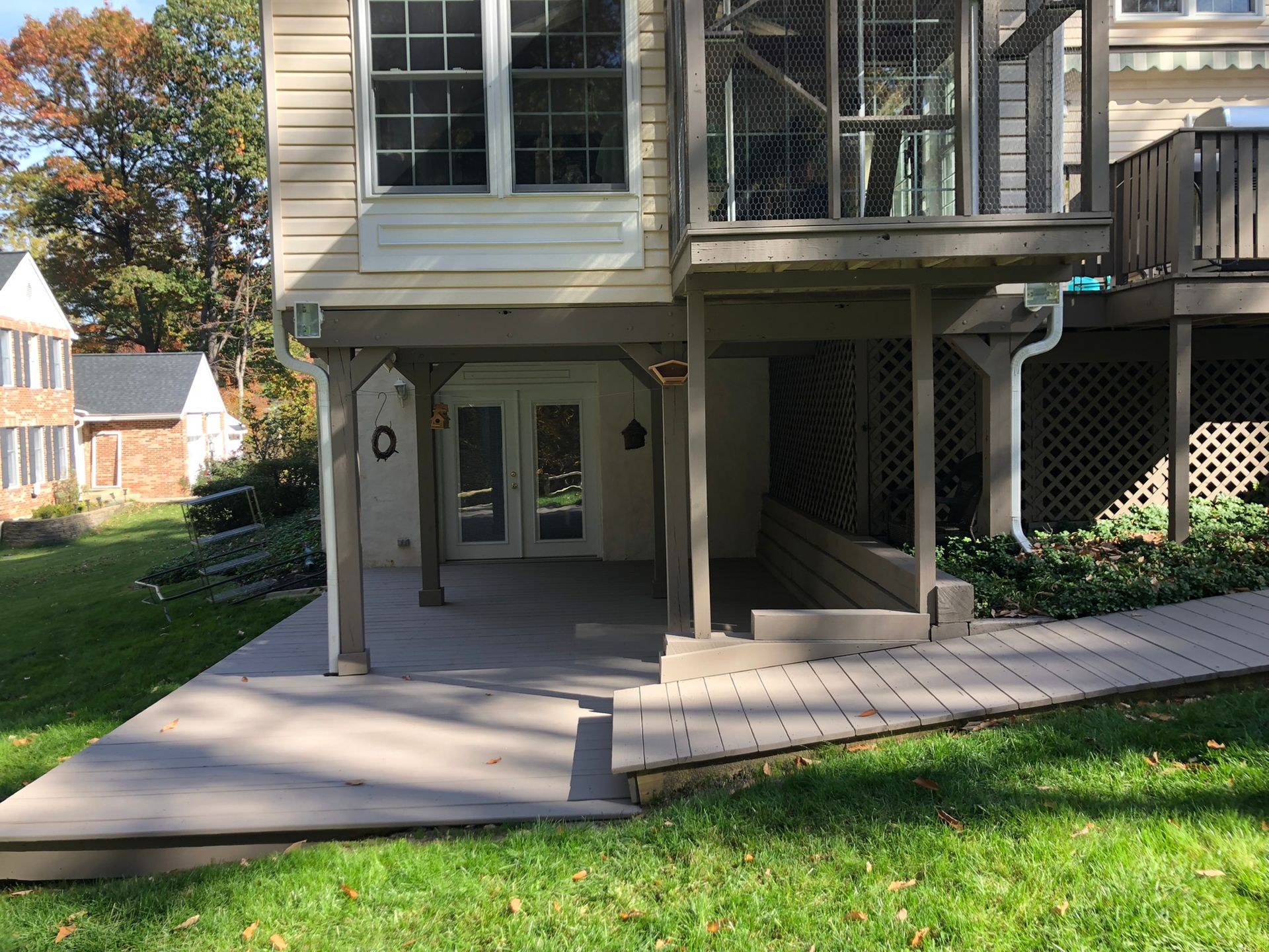 The back of a house with a patio and a screened in porch.