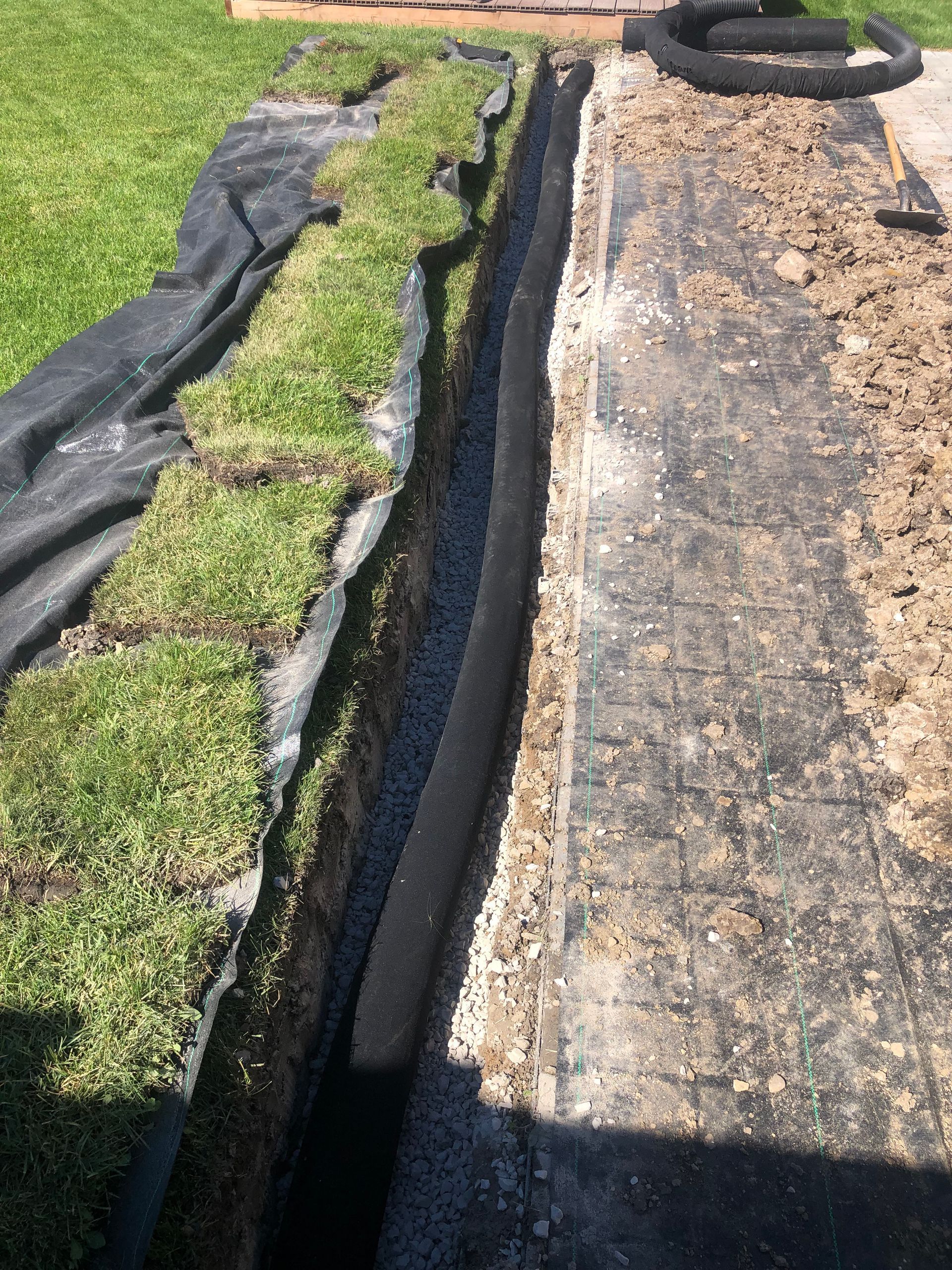 A drainage system is being installed in a backyard.